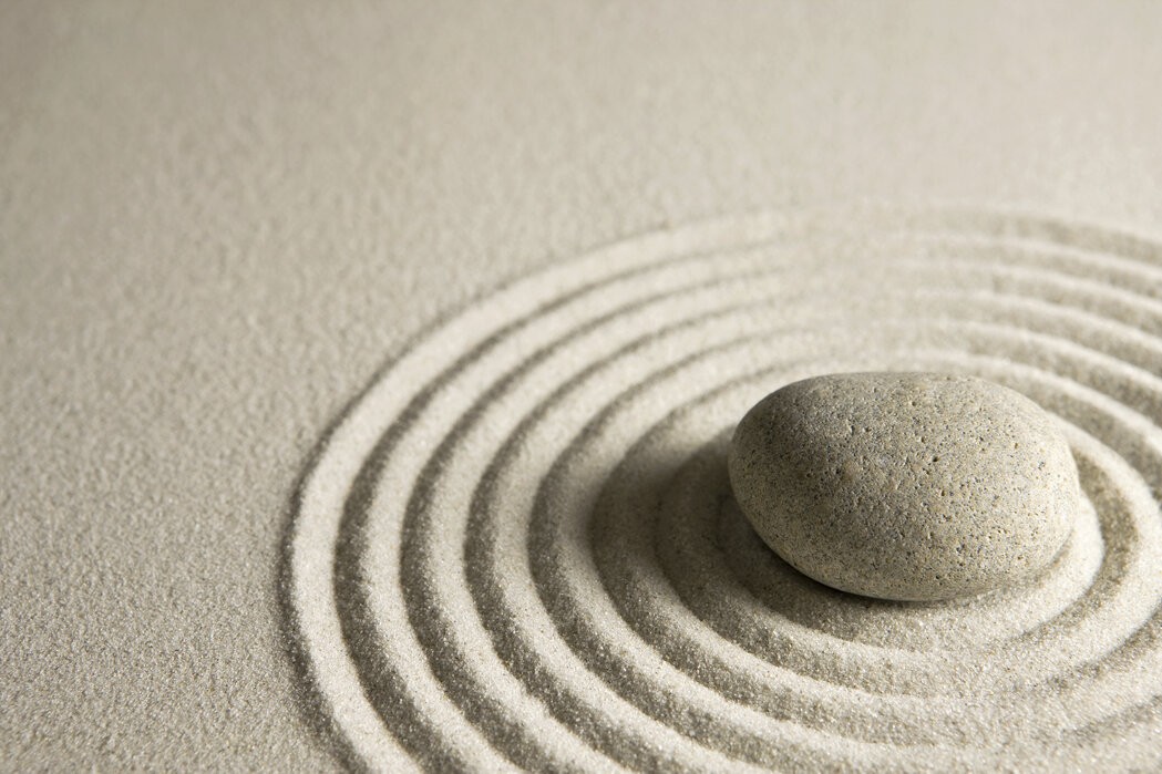 Giardino zen con spirale di pietre su sabbia rastrellata